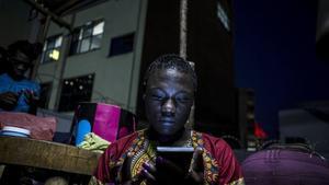 Una mujer mira a su teléfono en la capital de Uganda, Kampala.