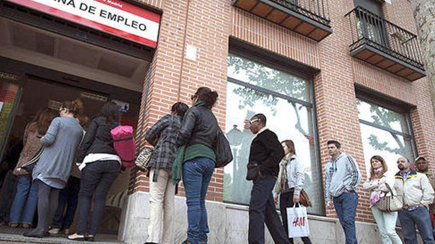 Gent fent cua davant una oficina de treball.