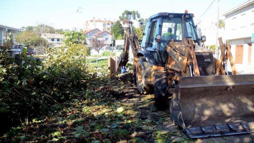 Maquinaria despejando el terreno en Os Campos. // Rafa Vázquez