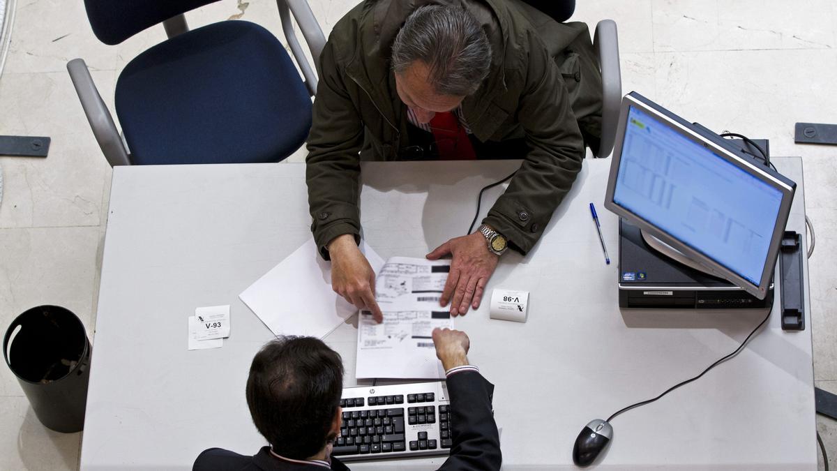 Un hombre realiza la declaración de la renta en una oficina.