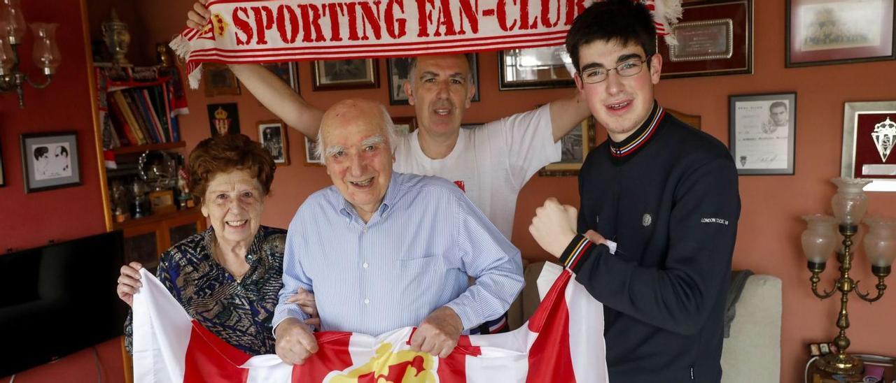 En el centro, Armando Medina sujeta su bandera del Sporting junto a su mujer, Acacia Peláez, su hijo Alejandro y su nieto Eloy, ayer, en su residencia gijonesa. | Marcos León