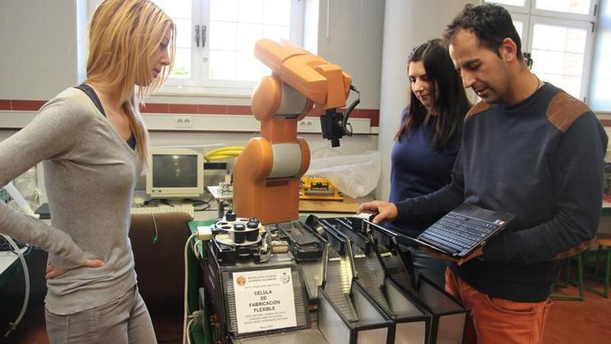 Alumna y profesor trabajan con un robot en el laboratorio.