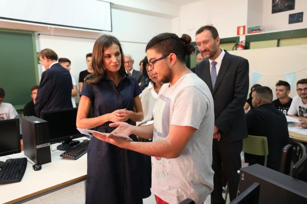 La reina charla con un alumno en un aula