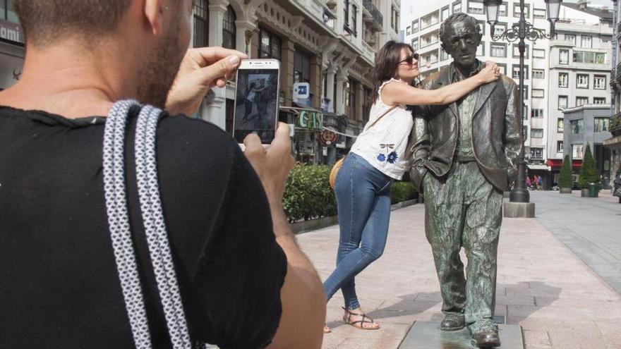 Una turista se fotografía junto a la estatua de Woody Allen en Oviedo