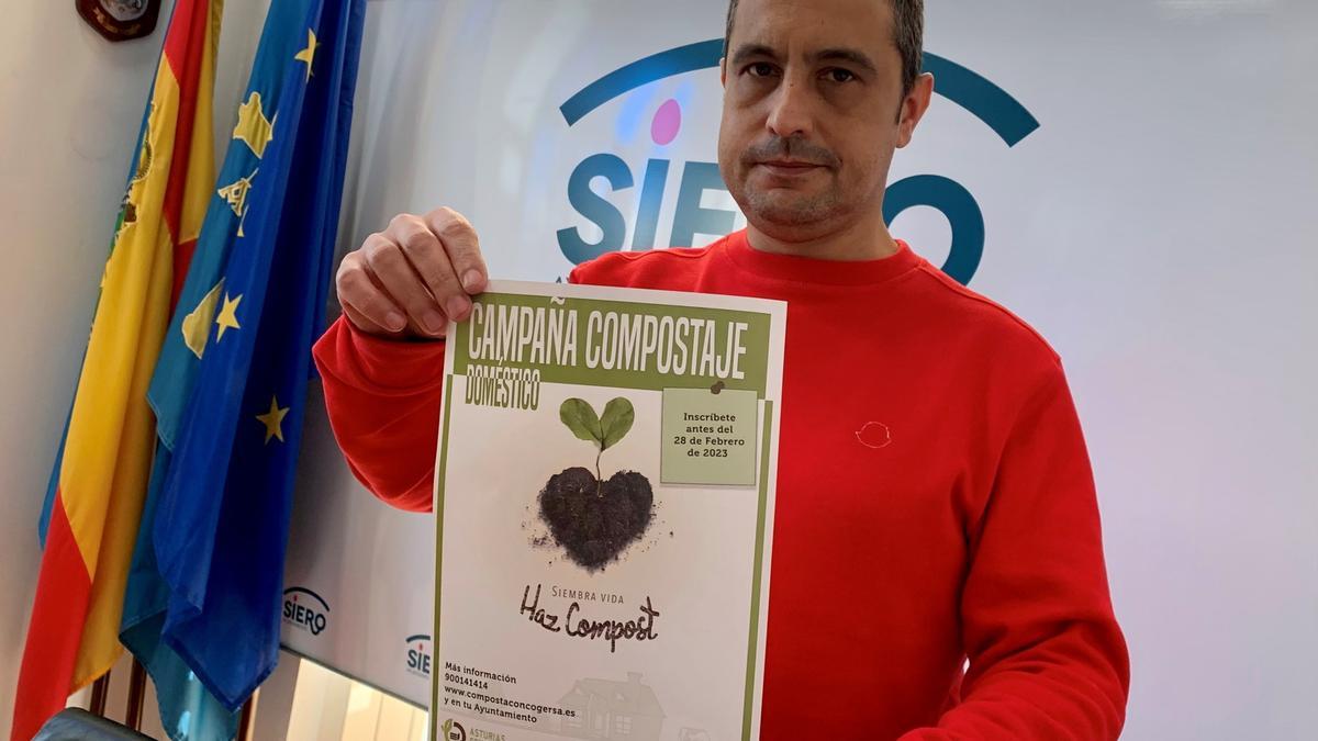 El edil Javier Rodríguez, con el cartel de la campaña de compostaje en Siero.