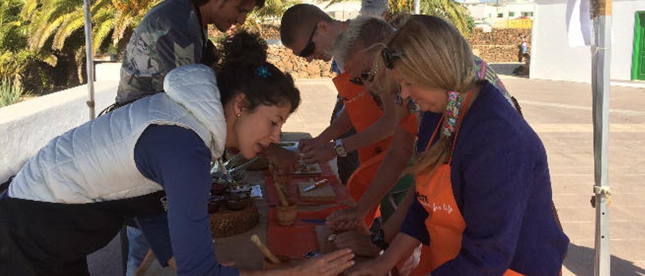 Estefanía González y Rayco Perdomo, ayer, en Teguise junto a la familia Norkes mientras elaboran su propio mojo.