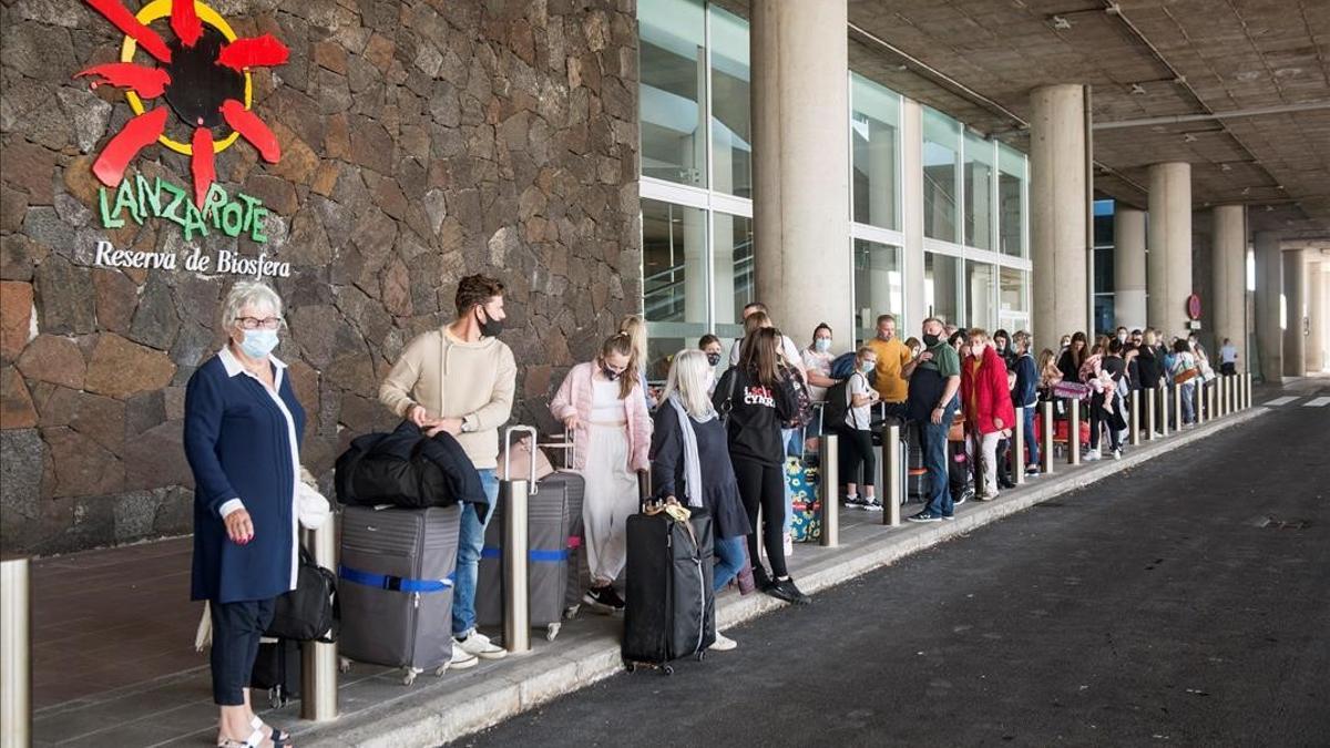 Varios turistas hacen cola para tomar un taxi a su llegada al aeropuerto Cesar Manrique de Lanzarote  este sabado  Canarias  comunidad espanola con la menor incidencia de la covid-19 a siete dias  con 43 51 casos por 100 000 habitantes  reactiva este sabado  con el regreso de alemanes y britanicos  su motor economico  el turismo  una apertura que el PP critica porque se hace sin  blindar  la region ante nuevos contagios  EFE JAVIER FUENTES