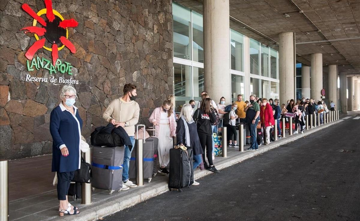 SAN BARTOLOME (LANZAROTE) 24 10 2020 - Varios turistas hacen cola para tomar un taxi a su llegada al aeropuerto Cesar Manrique de Lanzarote este sabado Canarias comunidad espanola con la menor incidencia de la covid-19 a siete dias con 43 51 casos por 100 000 habitantes reactiva este sabado con el regreso de alemanes y britanicos su motor economico el turismo una apertura que el PP critica porque se hace sin blindar la region ante nuevos contagios EFE JAVIER FUENTES SAN BARTOLOME (LANZAROTE) 24 10 2020 - Varios turistas hacen cola para tomar un taxi a su llegada al aeropuerto Cesar Manrique de Lanzarote este sabado Canarias comunidad espanola con la menor incidencia de la covid-19 a siete dias con 43 51 casos por 100 000 habitantes reactiva este sabado con el regreso de alemanes y britanicos su motor economico el turismo una apertura que el PP critica porque se hace sin blindar la region ante nuevos contagios EFE JAVIER FUENTES