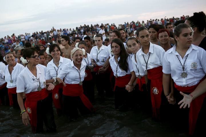 People in traditional costumes take part in the procession of the El Carmen Virgin being carried into the sea in Malaga