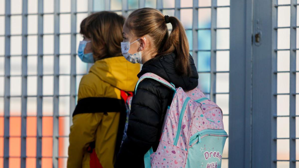 Dos niños entran en el colegio con mascarillas el pasado mes de febrero. | TONI ESCOBAR
