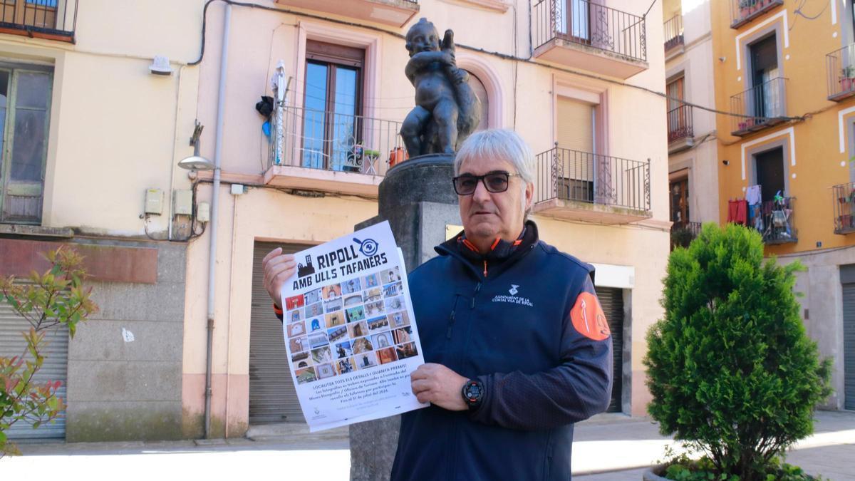 L'agent cívic Jordi Reolid amb el cartell i davant d'una de les escultures incloses en el projecte.