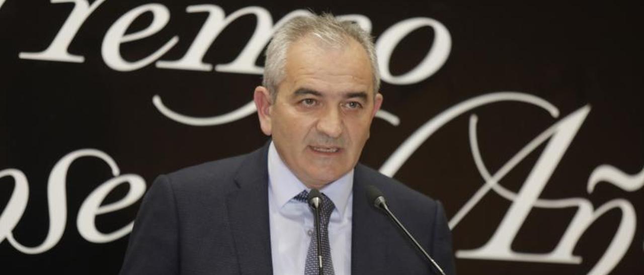 Fernando Delgado, durante una entrega de premios en Oviedo; en el cuadro, José Antonio García Santaclara. | Fernando Rodríguez / Clara Fernández