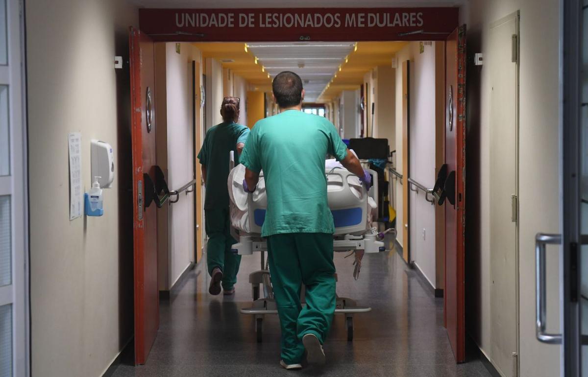 Personal sanitario accede con una camilla a la Unidad de Lesionados Medulares del Chuac.  | |  C. PARDELLAS