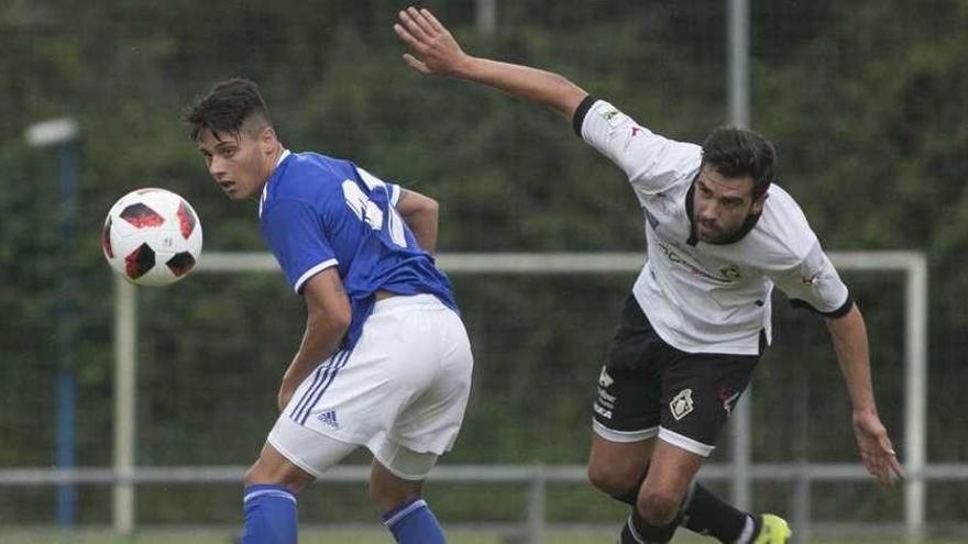 Eloy, del Oviedo B, a la izquierda, con Yosu Camporro, del Caudal, en el partido de ayer en El Requexón.