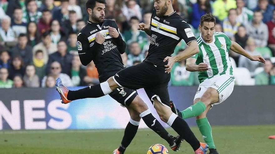 Álex Alegría golpea el balón ante la oposición de Insua y Timor.