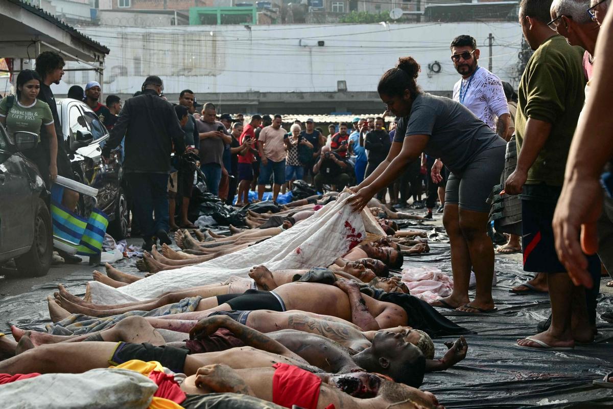 EDITORS NOTE: Graphic content / People line up bodies on Sao Lucas Square of the Vila Cruzeiro favela at the Penha complex in Rio de Janeiro, Brazil, on October 29, 2025, in the aftermath of Operacao Contencao (Operation Containment). Residents of a favela in Rio de Janeiro lined up more than 50 bodies at a plaza in their low-income neighborhood on Ocotber 29, a day after the bloodiest police operation in the citys history, AFP reported. (Photo by Pablo PORCIUNCULA / AFP). Graphic content