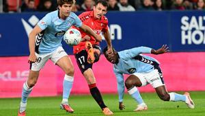 PAMPLONA, 26/10/2025.- El delantero de Osasuna Ante Budimir (c) chuta ante Marcos Alonso (i), del Celta, durante el partido de LaLiga de fútbol que CA Osasuna y Celta de Vigo disputan este domingo en el estadio de El Sadar, en Pamplona. EFE/Iñaki Porto