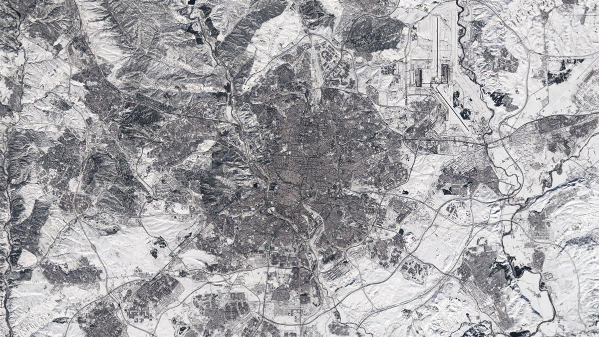 MADRID  12 01 2021 -En blanco y negro  asi es como se ve la imagen en color de Madrid desde el espacio  en la fotografia tomada por el satelite Sentinel-2 del sistema Copernicus de la Agencia Europea del Espacio (ESA) tras la gran nevada caida sobre la capital el pasado fin de semana al paso de la borrasca Filomena  La imagen fue tomada este lunes 11 por uno de los dos satelites que forman parte de la mision una vez ya habia pasado la borrasca  Sin embargo  esta captura deja en evidencia que todavia queda mucha nieve aunque se haya pasado la borrasca  especialmente en las afueras de la ciudad  La foto parece tomada en blanco y negro  pero sin embargo  se trata de una imagen en color real  aunque el paisaje se vea blanco debido a la mayor nevada caida sobre la region en 50 anos  En la copia facilitada por la Esa se puede apreciar como algunas de las pistas del aeropuerto (en la parte superior derecha de la imagen) aun siguen cubiertas de nieve  al igual que carreteras y vias de trenes -EFE  Agencia Europea del Espacio (ESA)  Solo uso editorial Solo disponible para ilustar la noticia que acompana