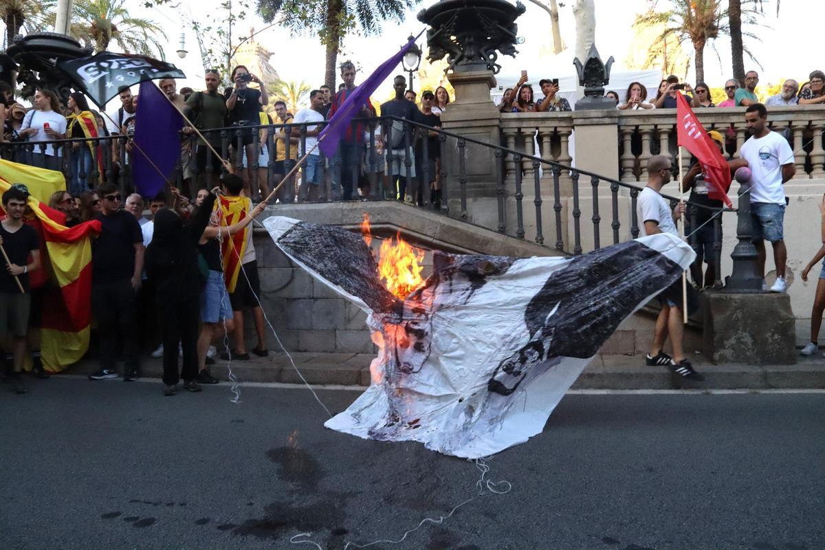 Uns encaputxats cremant una foto d'Aragonès i Collboni a la manifestació de l'esquerra independentista