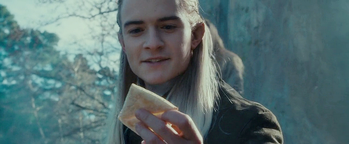Legolas, con un pan de lembas con la mano.