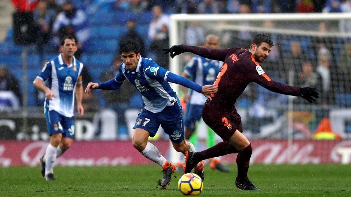 El defensa del FC Barcelona Gerard Piqué y el delantero del Espanyol Gerard Moreno durante el partido