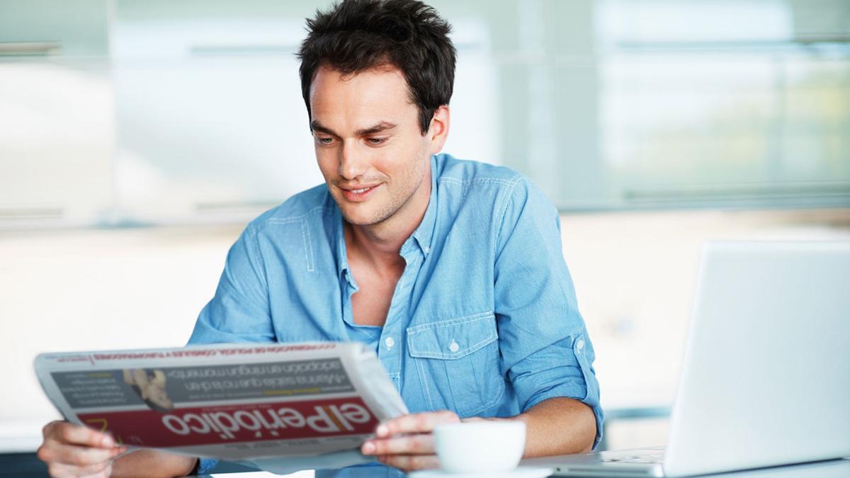 Un joven leyendo la edición impresa de El Periódico.