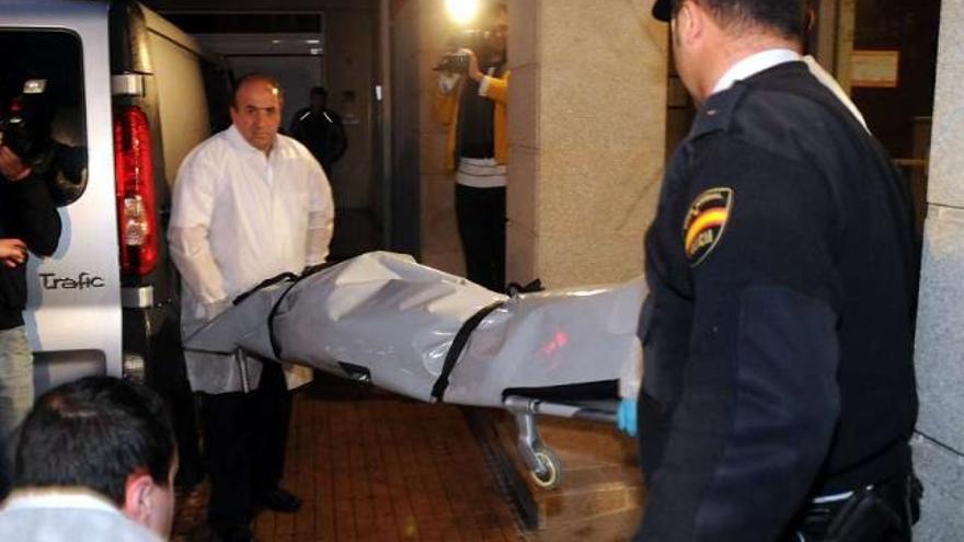 Uno de los cuerpos es trasladado a un coche fúnebre tras el asesinato ocurrido en 2009.  // Rafa Vázquez