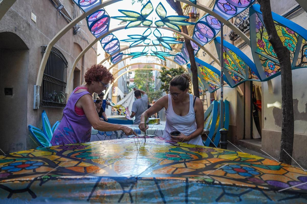 Vecinas de la calle de Tordera trabajan en la decoración de su calle para la celebración de las fiestas de Gràcia.