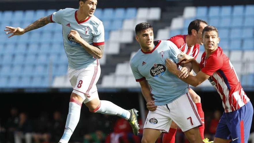 Pablo Hernández salta para rematar un córner junto a Godín y Maxi, que es sujetado por Lucas, durante al choque disputado ayer en Balaídos. // Ricardo Grobas