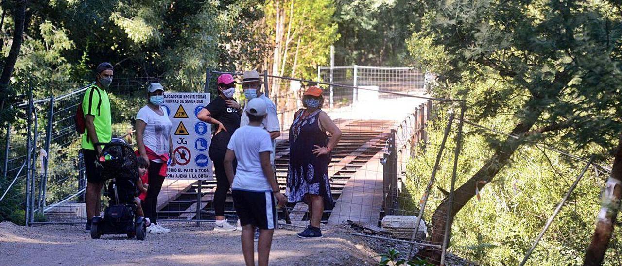 Usuarios de la vía verde pasean por esta senda antes de su inauguración oficial. A la izquierda el puente sobre el Umia, cortado por obras.