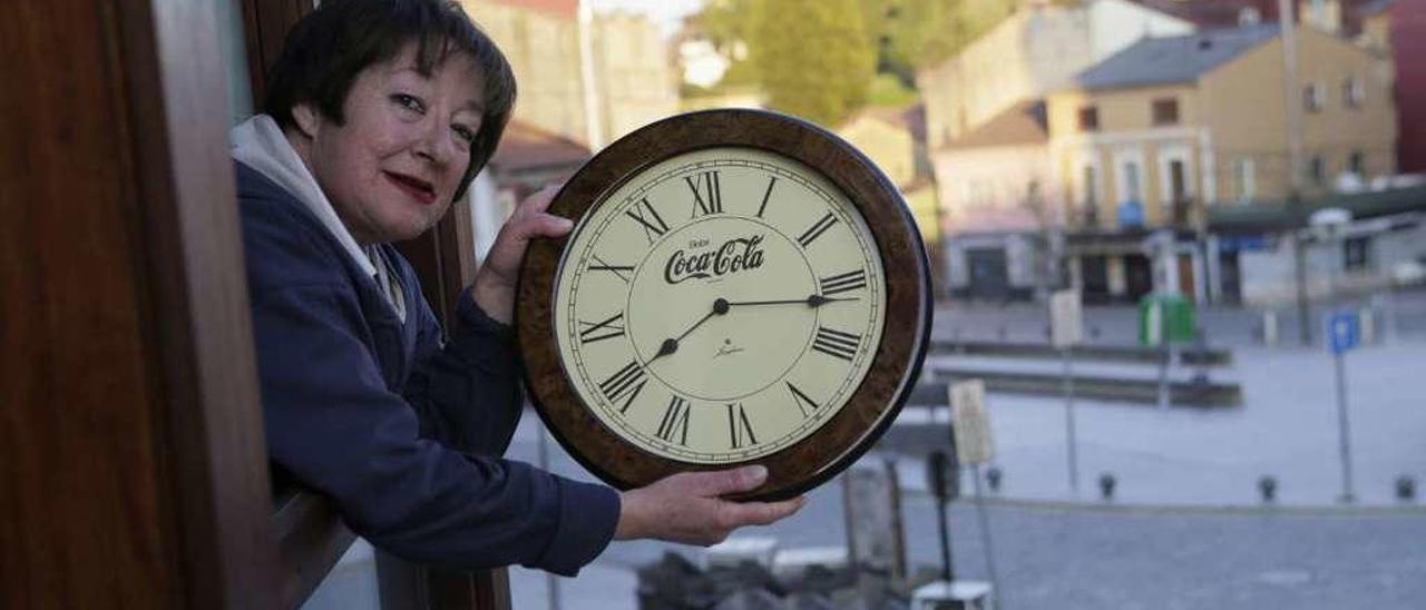 Belén Ardura, en Pola de Siero, con un reloj que muestra la hora hasta la que se puede aplaudir, las 20.15 horas.