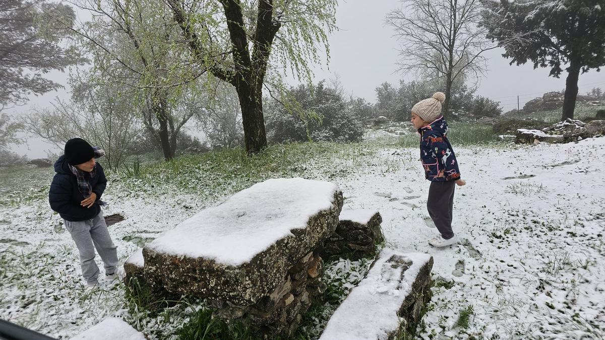 Dos niños juegan con la nieve en la Sierra de Cabra, junto al santuario.
