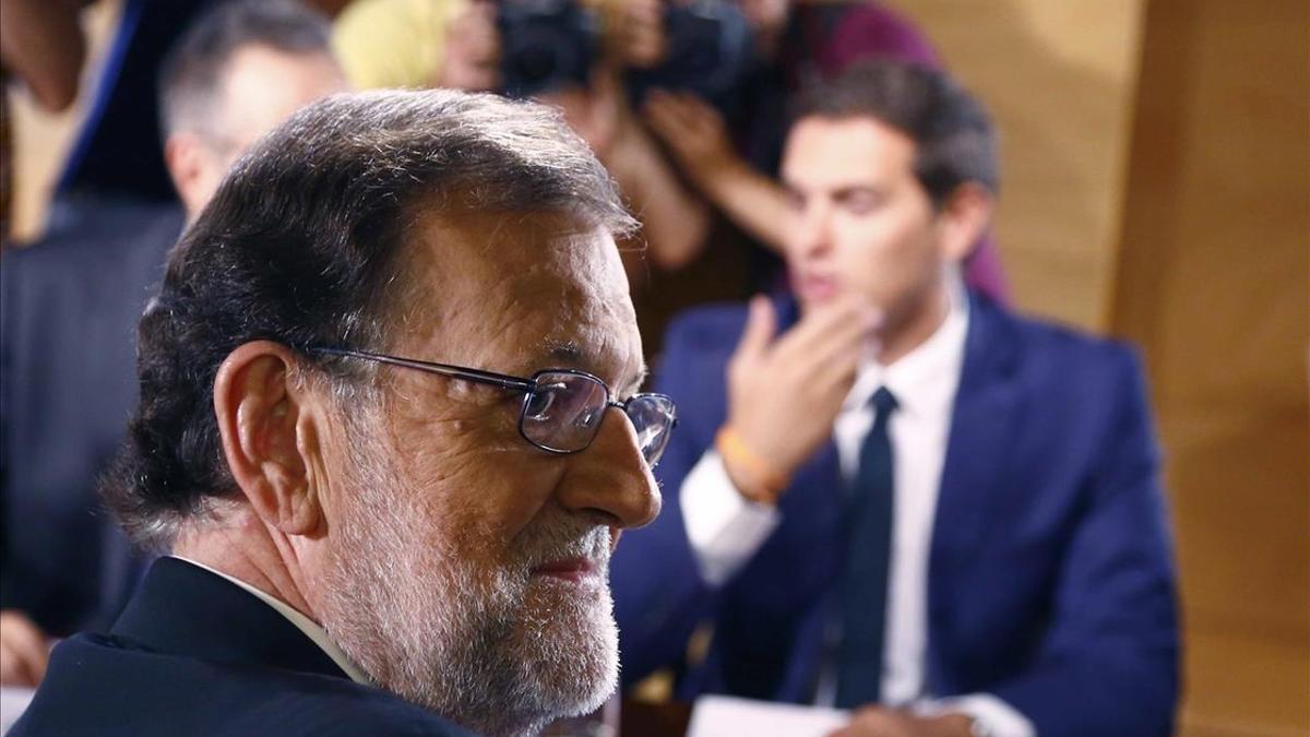 El presidente del Gobierno en funciones y líder del PP, Mariano Rajoy, en la firma del pacto de investidura con el jefe de Ciudadanos, Albert Rivera.