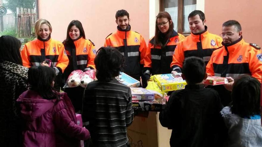 Voluntarios de Protección Civil de Piloña entregan juguetes a los niños del concejo, ayer.