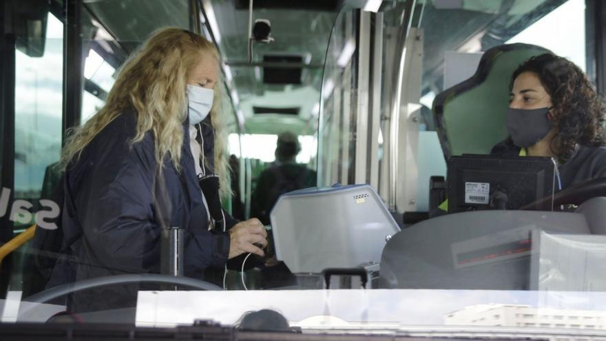 Una conductora atiende a una pasajera en la guagua de la línea 015 en el Intercambiador de La Laguna.