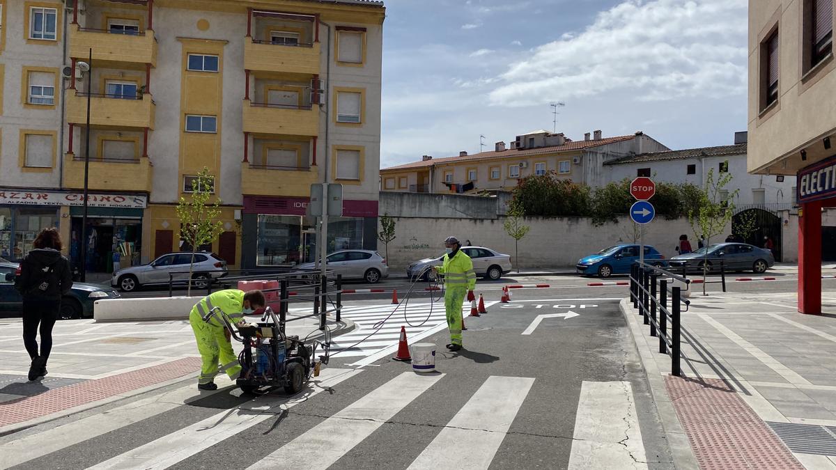 Operarios municipales pintan la señalización vial en la calle Almazara.