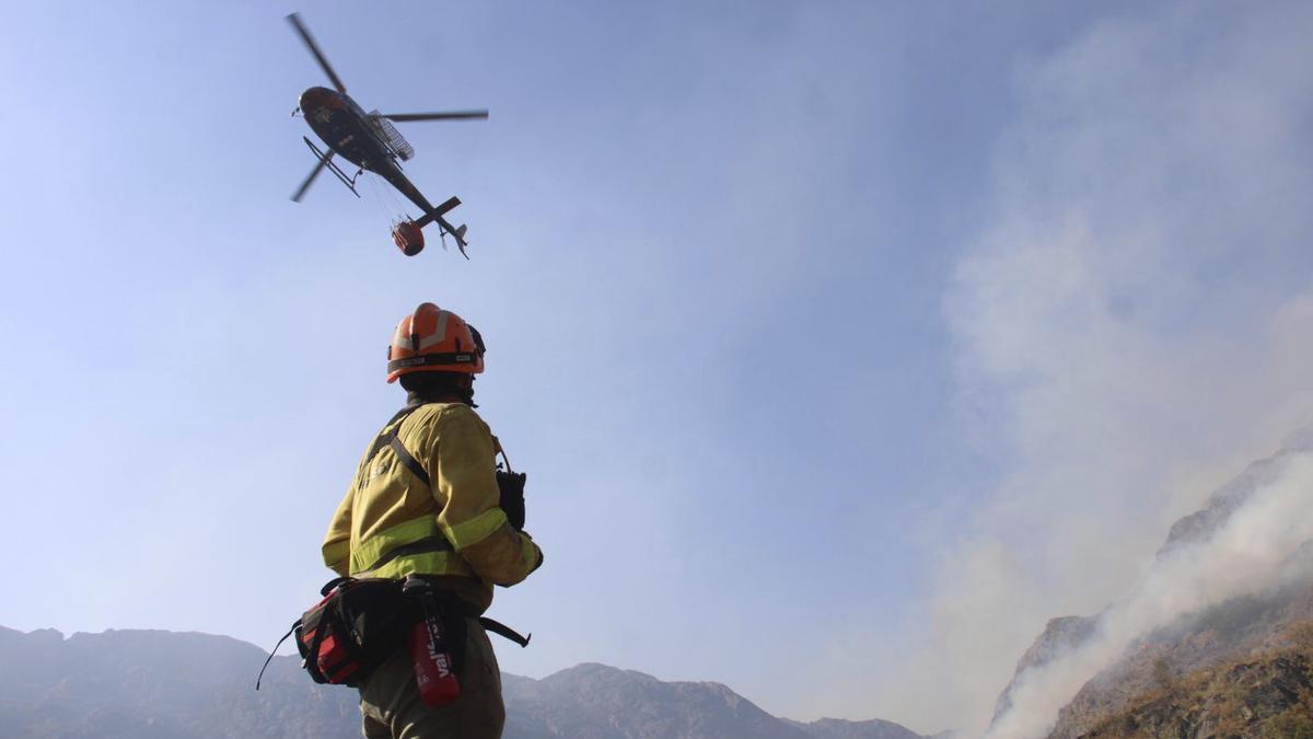 Un bombero forestal supervisa las labores de extinción aéreas en el incendio de Porto. | ARACELI SAAVEDRA
