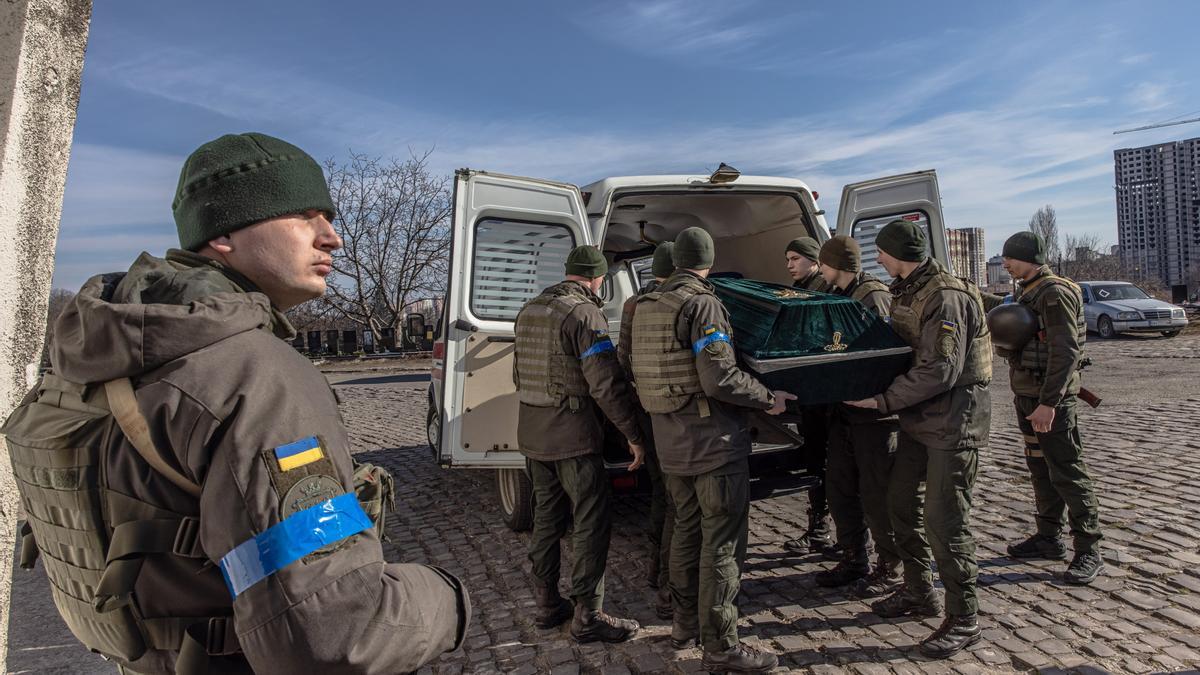 Miembros del ejército ucraniano portan el féretro cerrado con el cuerpo de Roman, un soldado ucraniano caído en la región de Kiev.