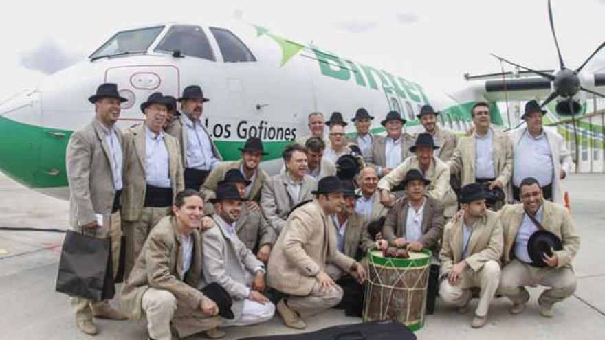 Integrantes del grupo folclórico Los Gofiones, ayer tras desvelar su nombre escrito en el morro de uno de los aviones de Binter Canarias. | josé carlos guerra