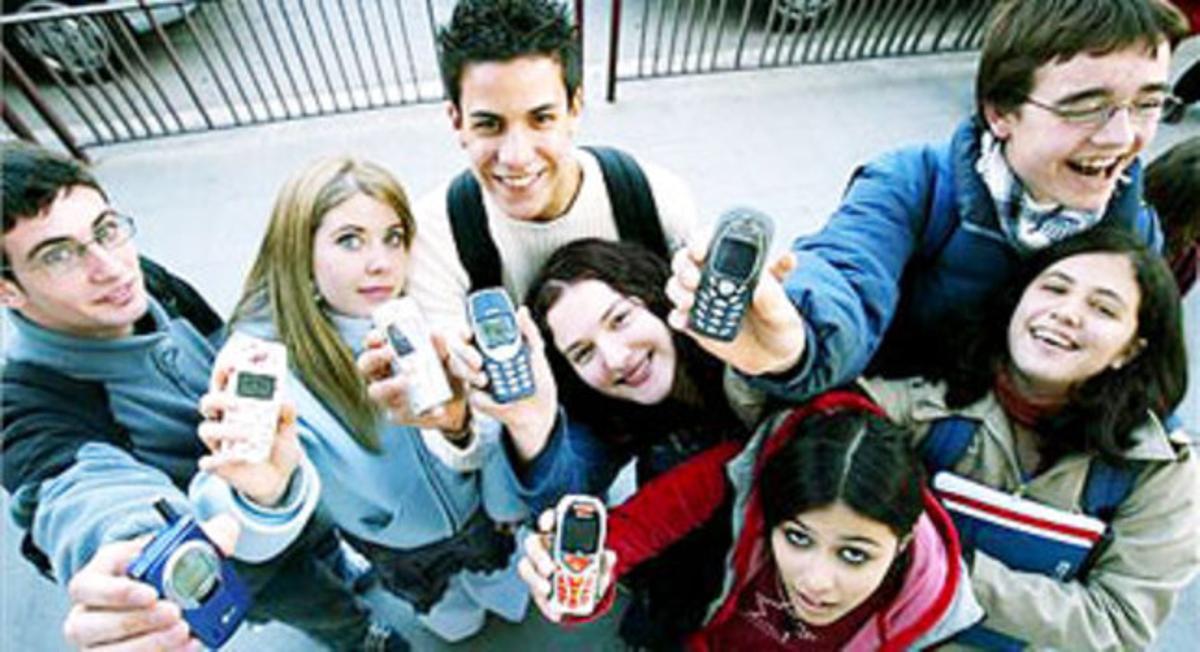 Un grup d’adolescents mostren els seus telèfons mòbils. Un grup d’adolescents mostren els seus telèfons mòbils.