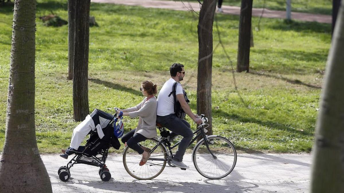 Una pareja con su bebé pasea por el cauce del Túria. | EFE/KAI FÖRSTERLING