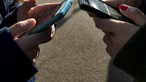 Adolescentes utilizando su teléfono móvil.