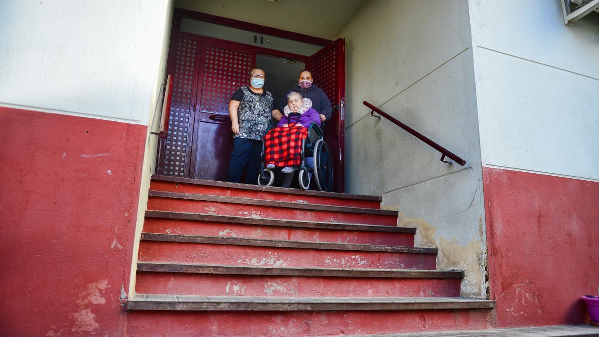 Luisa y su familia, ante los escalones que la impiden salir a la calle desde hace dos años.