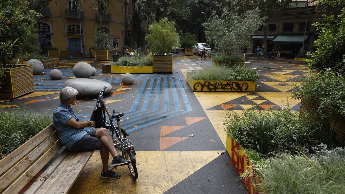 Un ciclista se toma un respiro en un banco de la supermanzana de Sant Antoni