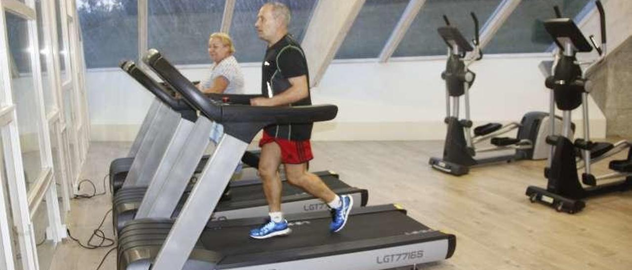 Dos personas haciendo uso de las máquinas del gimnasio. // Santos Á.