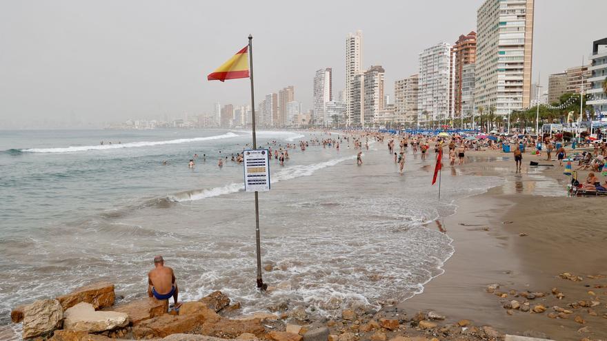 Los bañistas persisten en la playa de Levante de Benidorm pese al mal tiempo