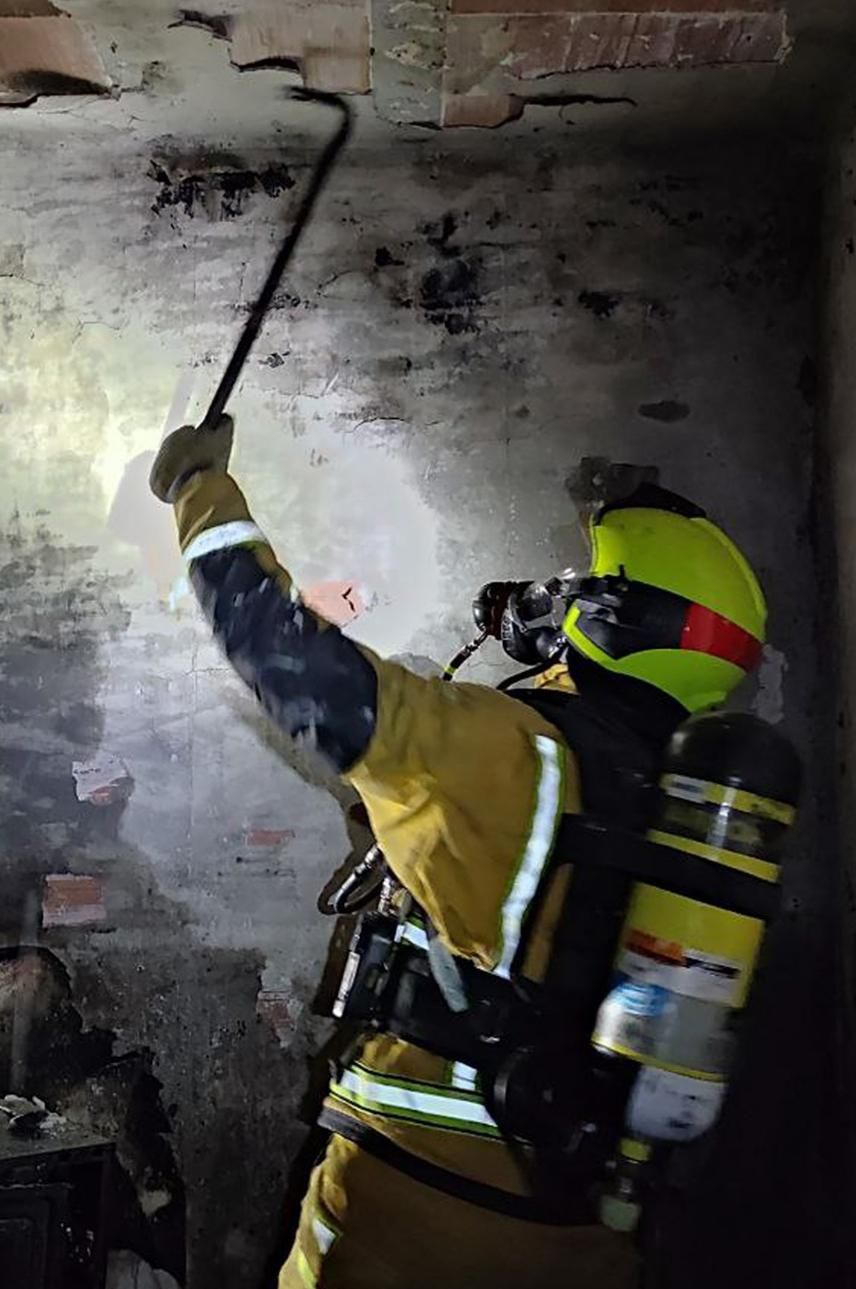 Un bombero inspeccionando el estado de la estructura del edificio tras el incendio.