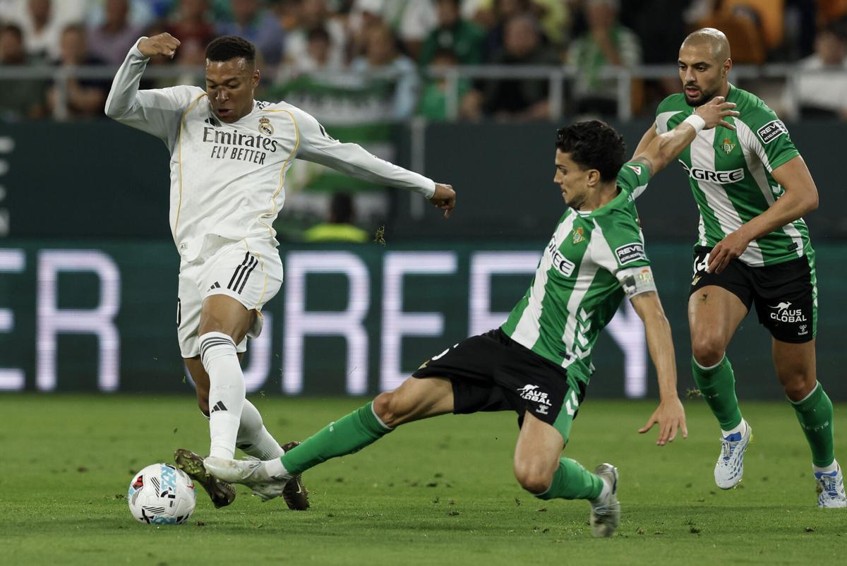 Marc Bartra trata de robar el balón a Kylian Mbappé