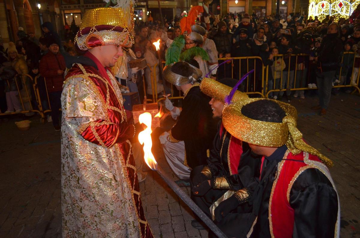 A la izquierda, Baltasar recibe la mirra para la adoración a Jesús.