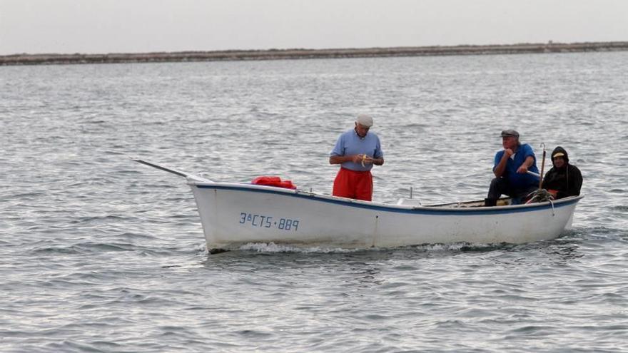 Tres pescadores navegan por el Mar Menor.